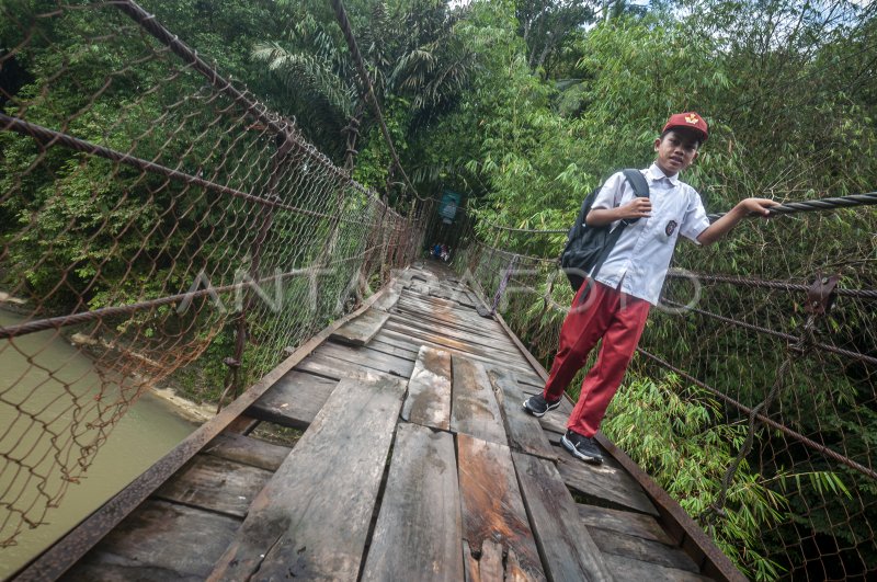 SISWA SEBERANGI JEMBATAN RUSAK MENUJU SEKOLAH DI LEBAK ANTARA Foto