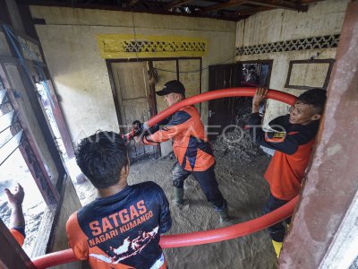 Des bénévoles du village aident au nettoyage des maisons après l&#039;inondation soudaine