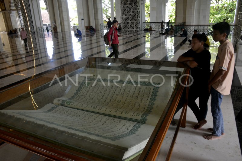 Al Quran dengan latar belakang masjid besar